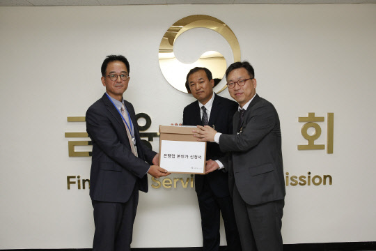 K뱅크 준비법인은 지난달 30일 금융위원회에 은행업 본인가 신청 관련서류 일체를 제출했다. 사진은 K뱅크 안효조 사업총괄본부장(오른쪽)과 옥성환 경영기획본부장(가운데)이 김진홍 금융위 은행과장(왼쪽)에게 본인가 신청 서류를 제출하고 있는 모습.  K뱅크 제공
